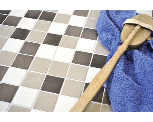 Carreaux carrés de différentes couleurs avec une brosse et une serviette bleue