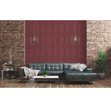 Salon avec papier peint rouge et motif géométrique, combiné avec un mur en briques