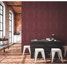 Espace de vie avec papier peint à motifs, plancher en bois et table à manger avec tabourets.