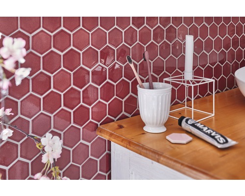 Scène de salle de bain avec carrelage hexagonal, brosses à dents, dentifrice et décoration sur un lavabo