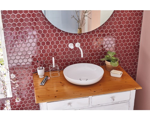 Salle de bain moderne avec miroir rond, lavabo à poser et carreaux muraux hexagonaux