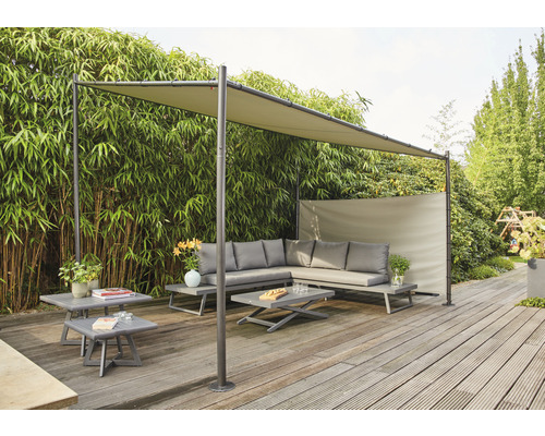 Groupe de salon de jardin avec toit de protection solaire sur terrasse en bois devant une haie de bambous