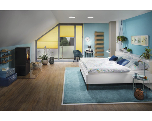 Schlafzimmer im Dachgeschoss mit Bett, Kaminofen und Plissee Rollos