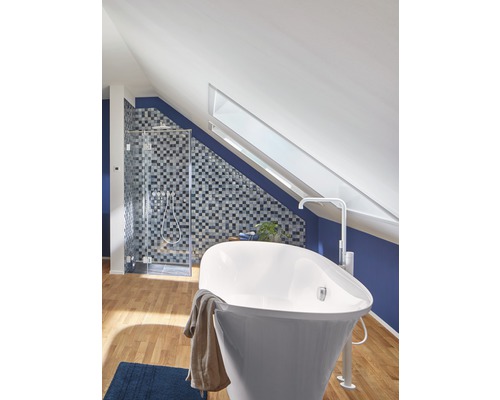 Salle de bain avec baignoire, douche et fenêtre de toit dans une maison