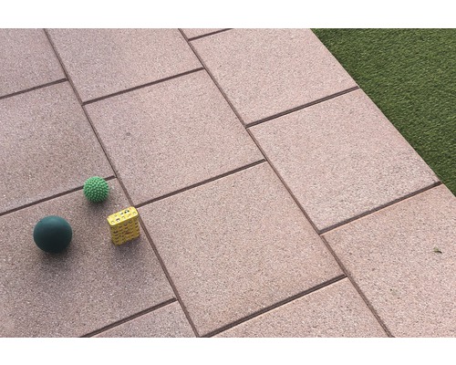 Verlegte Terrassenplatten mit Spielbällen und einem Würfel