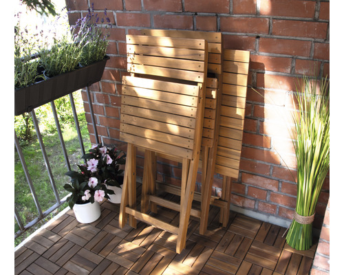 Scène de balcon avec tables pliantes en bois, plantes en pot et mur de briques