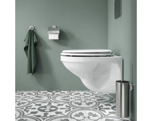 Salle de bains moderne avec WC suspendu, serviette, dérouleur de papier toilette et brosse de toilette