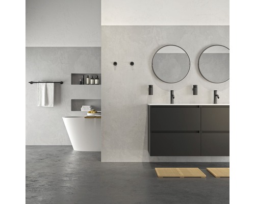 Salle de bains lumineuse avec double vasque, miroirs ronds, baignoire et serviettes