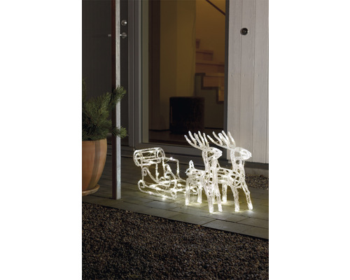 Traîneau illuminé avec des rennes comme décoration de Noël devant une porte d''entrée.