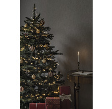 Sapin de Noël décoré avec des cadeaux et une bougie sur une table