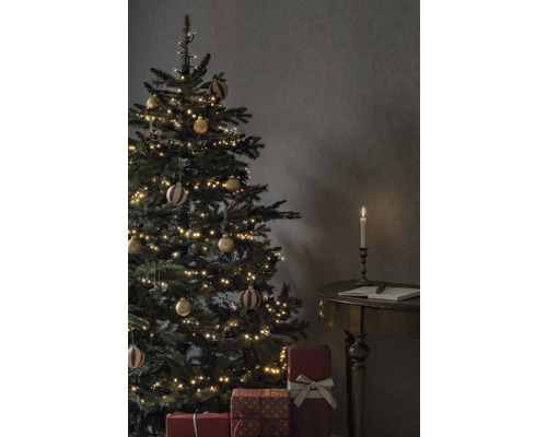 Sapin de Noël décoré avec des cadeaux et une bougie sur une table