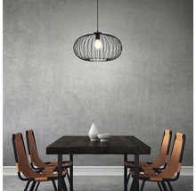 Salle à manger avec table en bois, chaises et suspension noire.