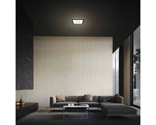 Salon avec plafonnier encastré moderne au-dessus d''un canapé gris.