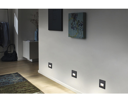 Flur mit Wandleuchten, Gemälden und Teppich für stimmungsvolle Beleuchtung