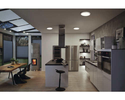 Cuisine d'habitation moderne et lumineuse avec îlot de cuisine, coin repas, cheminée et plafonniers