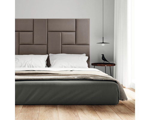 Chambre avec tête de lit rembourrée, table de chevet et lampe