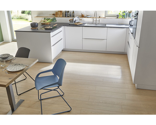 Heller und geräumiger Küchenbereich mit weißen Schränken, dunklen Arbeitsplatten, Holzböden, Esstisch und Stühlen