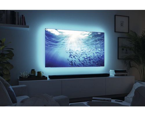 Wohnzimmer mit Fernseher mit Hintergrundbeleuchtung und Soundbar auf einem Schrank