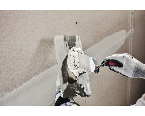 Artisan lissant du mastic avec un couteau à mastic