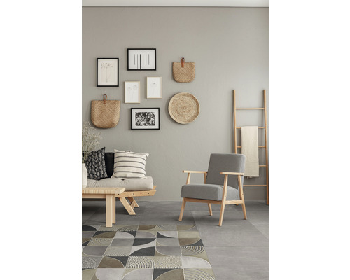 Salon avec canapé, fauteuil, tapis et décorations murales