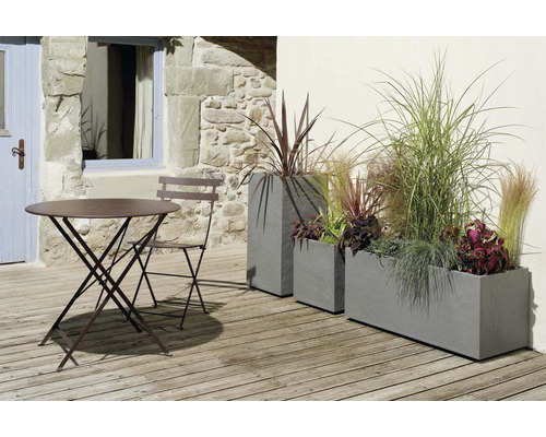 Gartenszene mit Tisch, Stuhl und bepflanzten Pflanzkästen auf einer Terrasse