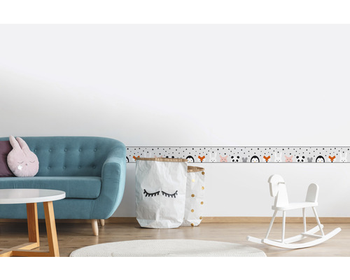 Kinderzimmer mit Sofa, Tisch, Spielzeug und Bordüre mit Tiermotiven