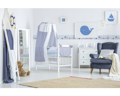 Babyzimmer im maritimen Stil mit Gitterbett, Sessel und passender Dekoration