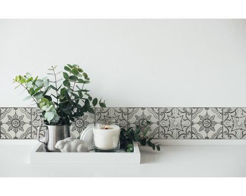 Bordure murale à motif floral, eucalyptus dans un pichet et bougie sur un plateau