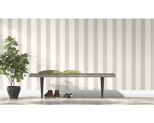 Raumansicht mit gestreifter Tapete, Bank, Kissen, Schuhen und Zimmerpflanze