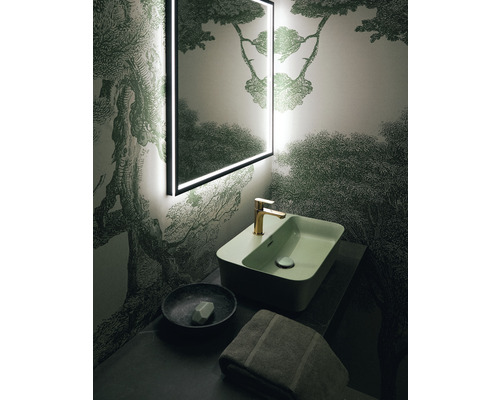 Badezimmer mit beleuchtetem Spiegel, Waschtisch und Tapete mit Waldmotiv