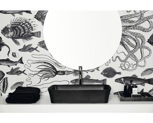 Plan de toilette avec robinetterie, miroir, serviettes et accessoires devant un papier peint à motifs marins