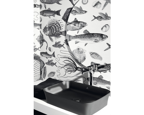 Un lavabo à poser foncé avec robinet devant un papier peint à motifs de poissons