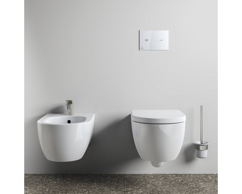 Wandhängendes WC, Bidet, Betätigungsplatte und Toilettenbürstengarnitur in einem Badezimmer
