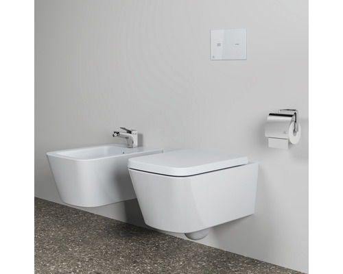 Wandhängendes WC mit Bidet, Spültaste und Toilettenpapierhalter in einem modernen Badezimmer.