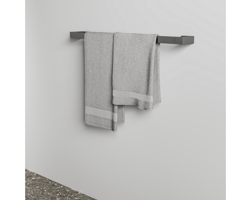 Porte-serviettes gris avec deux serviettes sur un mur