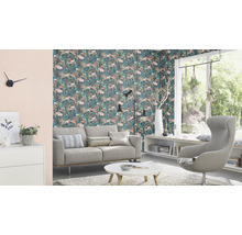 Wohnzimmer mit Sofa, Sessel und floraler Tapete für ein helles Ambiente