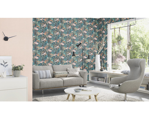 Wohnzimmer mit Sofa, Sessel und floraler Tapete für ein helles Ambiente