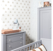 Ein Kinderzimmer mit einer Wickelkommode, einem Kleiderschrank und einer Wand mit Regenbogenmuster.