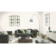 Wohnzimmer mit Ledersofas, Holztisch und dezent gemusterter Tapete.