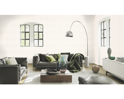 Wohnzimmer mit Ledersofas, Holztisch und dezent gemusterter Tapete.