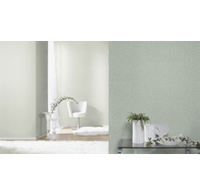 Heller, freundlicher Raum mit strukturierten Tapeten und dekorativen Elementen.