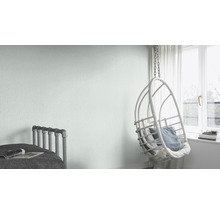 Helles Zimmer mit Bett, Hängesessel und hellgrüner Vliestapete