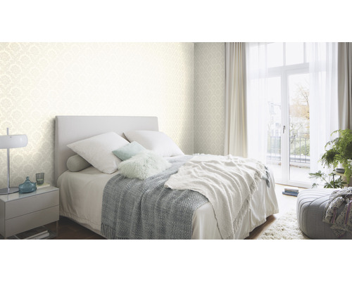 Helles Schlafzimmer mit Bett, Nachttisch und gemusterter Tapete