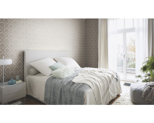 Schlafzimmer mit gemusterter Tapete, Bett und Nachttisch