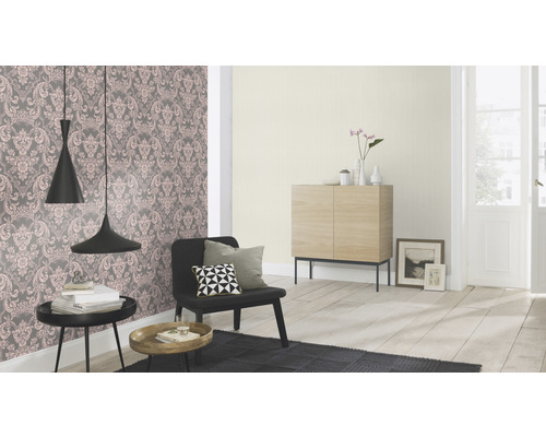 Wohnraum mit gemusterter Tapete, Sessel und Dekoration