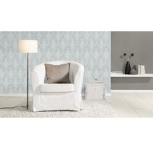 Wohnzimmer mit Sessel, Stehlampe und gemusterter Tapete