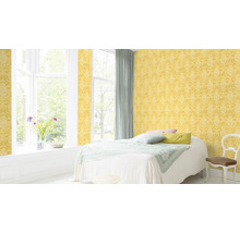 Helles Schlafzimmer mit gelber gemusterter Tapete, Bett und Fenster