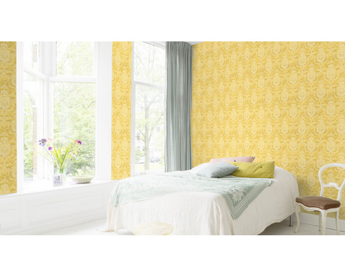 Helles Schlafzimmer mit gelber gemusterter Tapete, Bett und Fenster