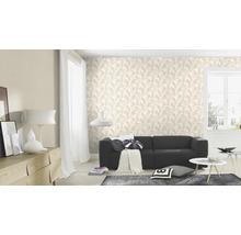 Wohnzimmer mit Tapete mit Blättermotiv, Sofa und Wohnaccessoires.