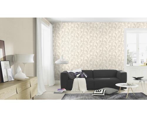 Wohnzimmer mit Tapete mit Blättermotiv, Sofa und Wohnaccessoires.